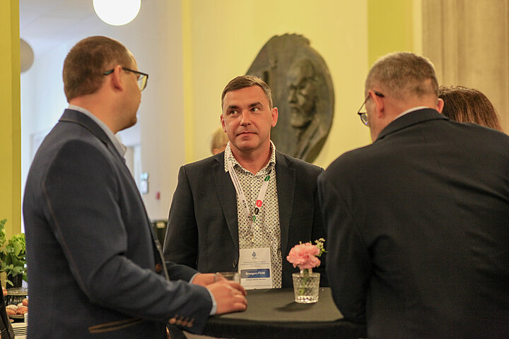 Na zdjęciu widać osoby rozmawiające ze sobą w czasie przerwy kawowej