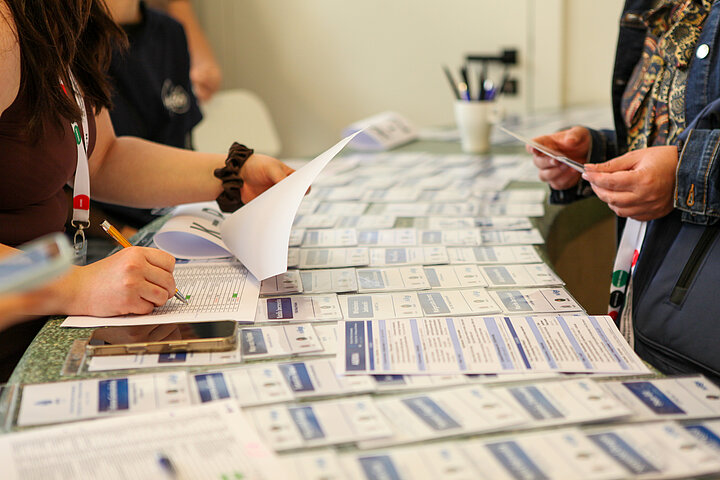 Na zdjęciu widać stanowisko rejestracji na konferencję oraz rozłożone identyfikatory