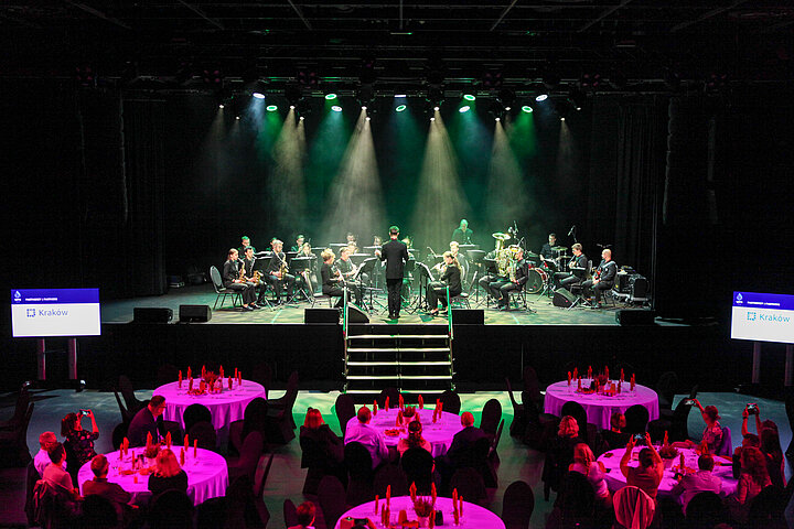 Na zdjęciu widać wnętrze klubu Studio, widać scenę, na której odbywa się koncert ORAGH, widać również stoliki z uczestnikami konferencji