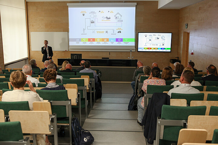 Na zdjęciu widać wnętrze sali audytoryjnej, w której odbywa się wykład oraz widać uczestników