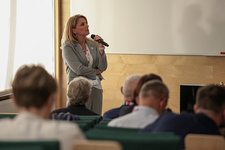 Na zdjęciu widać panią prezentującą wykład oraz salę w której siedzą słuchacze