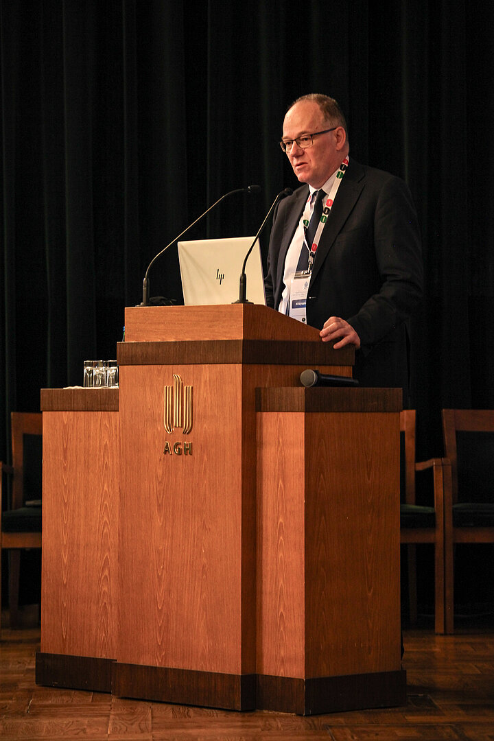 Na zdjęciu widać mężczyznę przemawiającego z ambony, jest to Główny Geolog Kraju